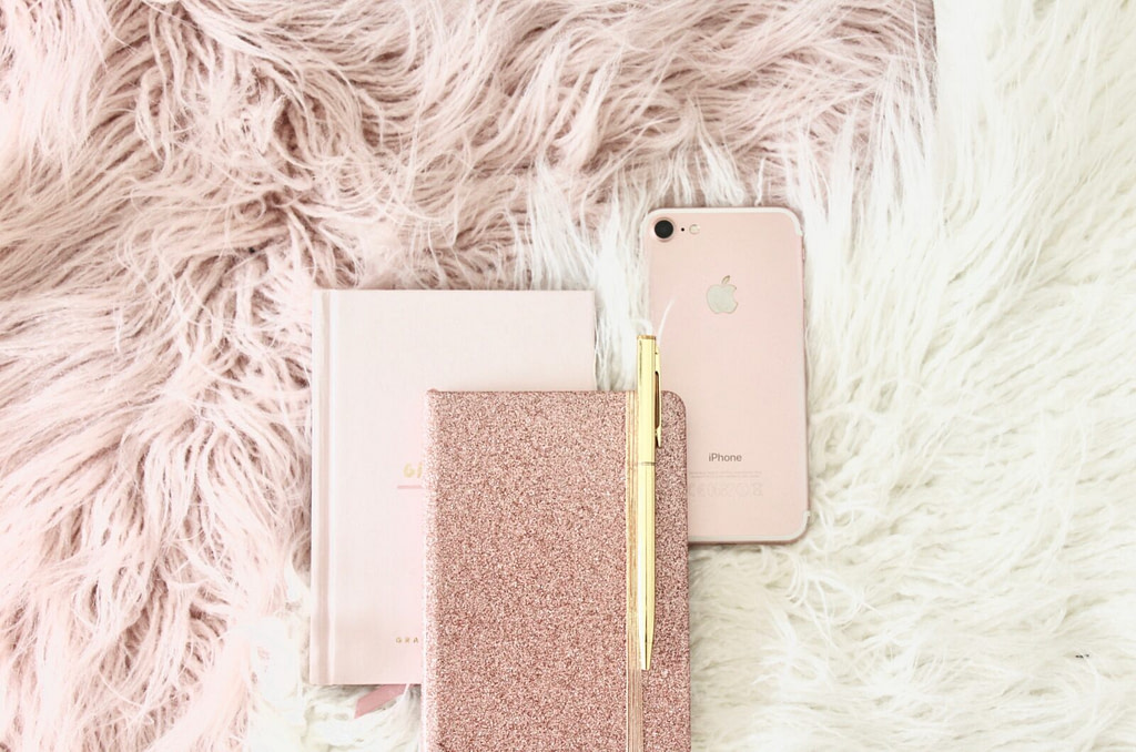 gold iPhone 8 beside book