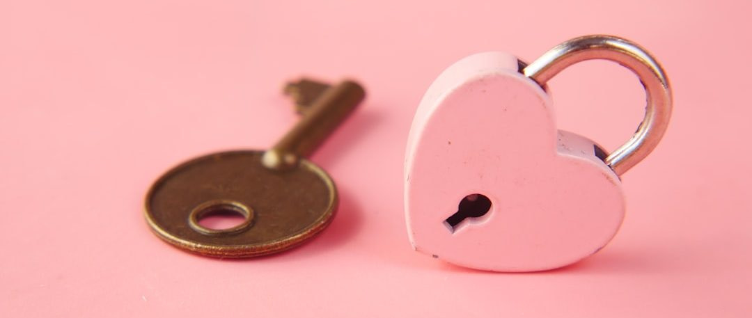 a heart shaped lock and a key on a pink background