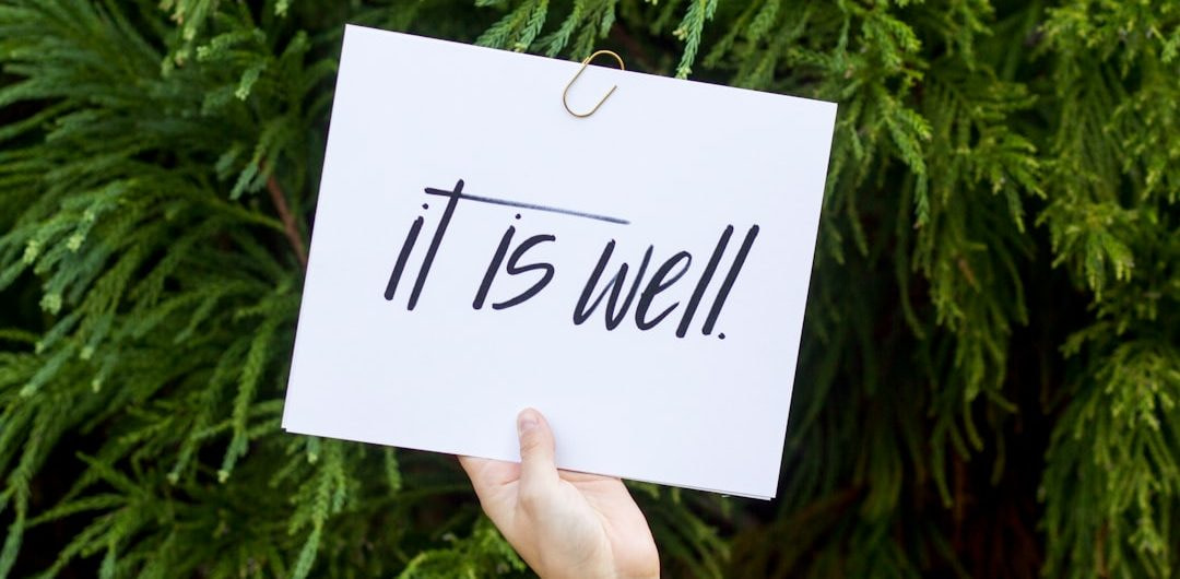 person holding white paper with it is well text