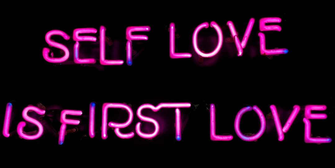 a neon sign that says self love is first love