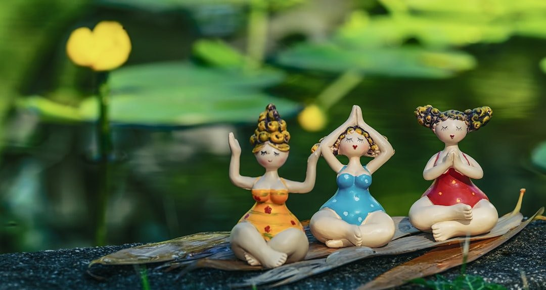 three little figurines are sitting on a leaf