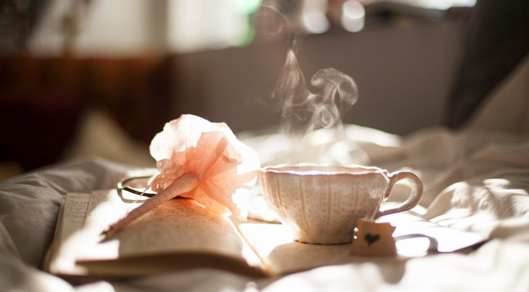 teacup on book beside pink flower decor