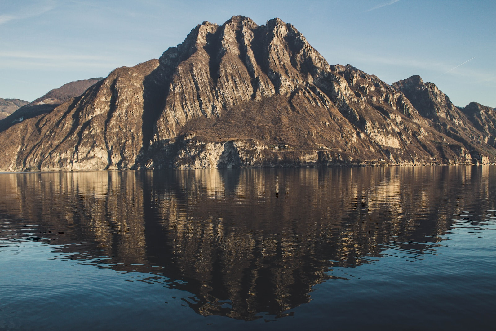 brown mountain across body of water