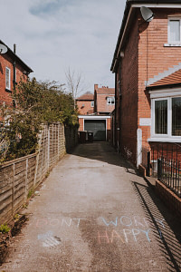 brown brick house near green trees during daytime
