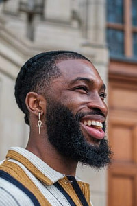 man in white and brown striped shirt smiling