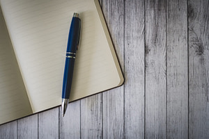 blue click pen on brown wooden table