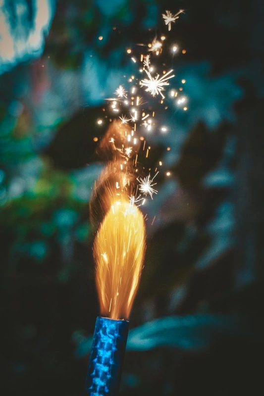 Bright firework candle burning on blurred background in evening