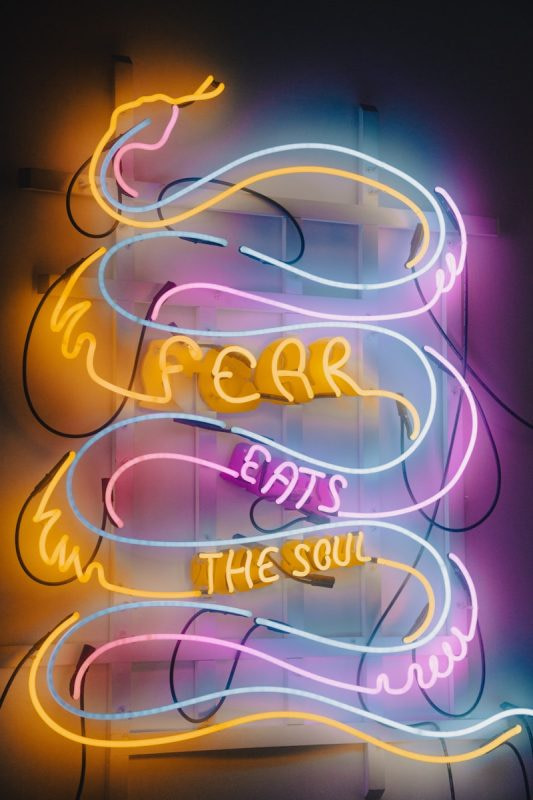 a neon sign that says fear eats the soul