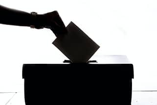 person dropping paper on box