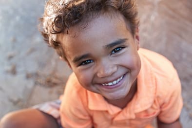 boy in orange polo shirt smiling