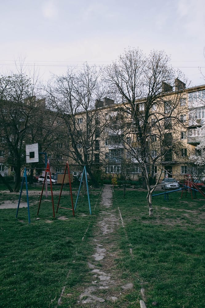 a playground with trees and buildings in the background