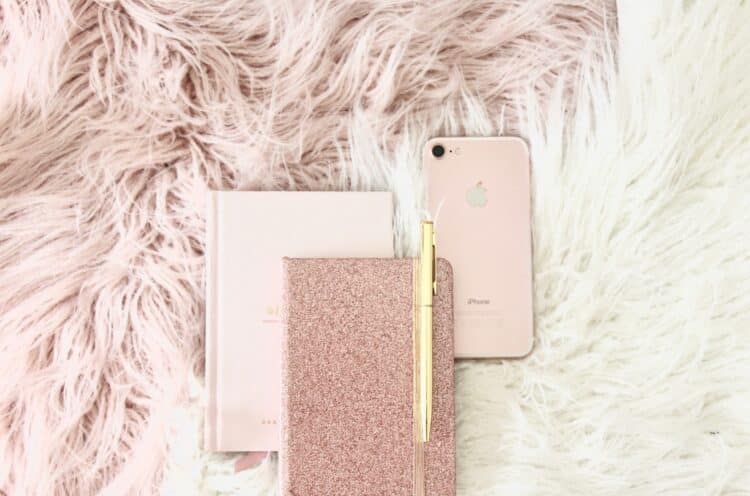 gold iPhone 8 beside book